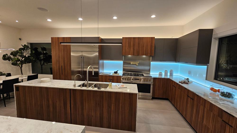 Contemporary kitchen with Dark Italian Walnut veneer cabinets and LED accent lighting