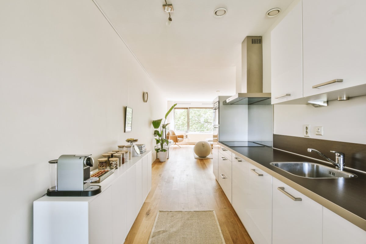 Modern galley kitchen featuring 12-inch deep base cabinets in a compact layout with white flat-panel doors and minimalist decor