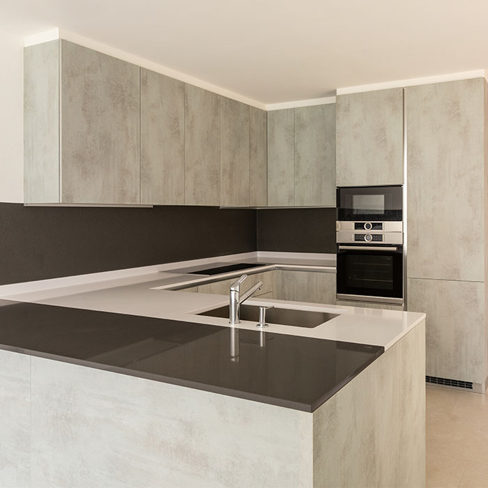 Modern European kitchen with concrete-look cabinet doors and integrated appliances
